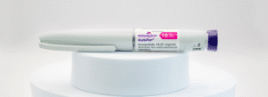 A Mounjaro KwikPen injection pen labeled 16.67 mg/mL, resting horizontally on a white circular platform.